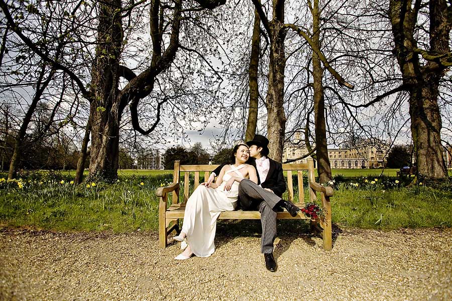Couple sitting on a King\'s College bench for their wedding